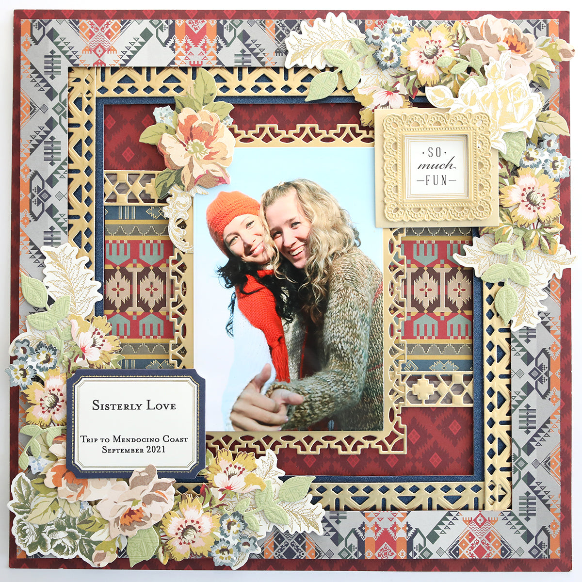 A decorative frame from our exclusive Lomasi Cardstock Collection features floral and Native American patterns, showcasing a photo of two people smiling and holding hands. Text reads "Sisterly Love," "Trip to Mendocino Coast September 2021," and "So much FUN.