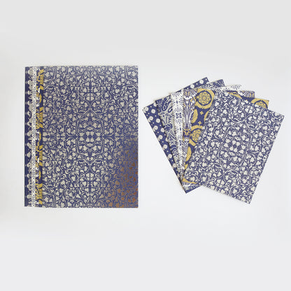 The Luxury Luster Foil Cardstock set includes a blue and gold patterned notebook beside five matching loose sheets with ornate designs, all displayed on a plain white background.