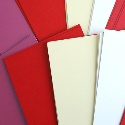 The Luxury Shimmer Cardstock - Lovely offers an array of colorful paper sheets in red, cream, and purple tones. This cardstock is perfect for handmade cards as it adds an elegant touch with its overlapping pattern that beautifully reflects light.