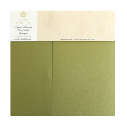 Luxury Shimmer Cardstock - Antique in green, adorned with a decorative label showcasing a gold embossed logo and text. Ideal for die cut projects, each sheet glistens magnificently, infusing your crafts with an elegant embossed flair.