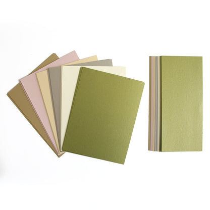 The Luxury Shimmer Cardstock - Antique features an exquisite assortment of sheets in shades of green, beige, pink, and gray. They are beautifully displayed in a fan shape on the left and a vertical stack on the right against a white background, perfect for embossing or die cutting to infuse sophistication into your projects.