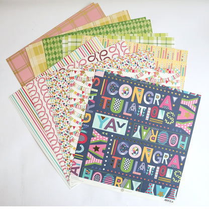 A stack of Mystery Birthday 12x12 Cardstock sheets, featuring vibrant patterns and "Congratulations" text with geometric designs—ideal for creative birthday crafting projects.