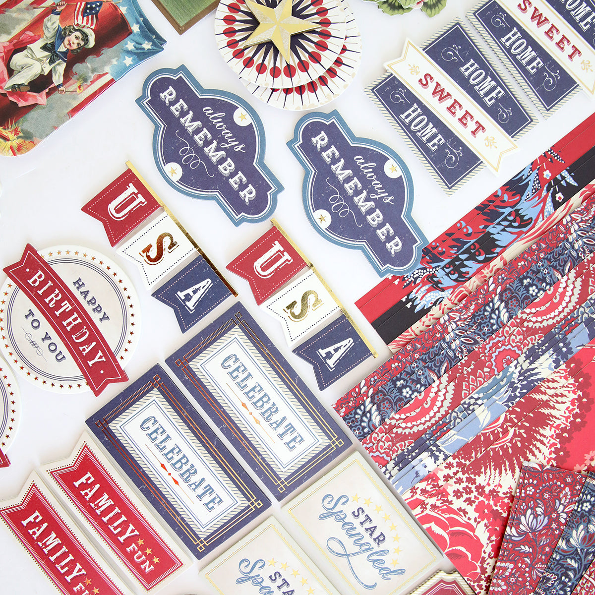 The Madison Paper Crafting Collection of patriotic stickers and papers, featuring vintage spirit, displayed on a table.