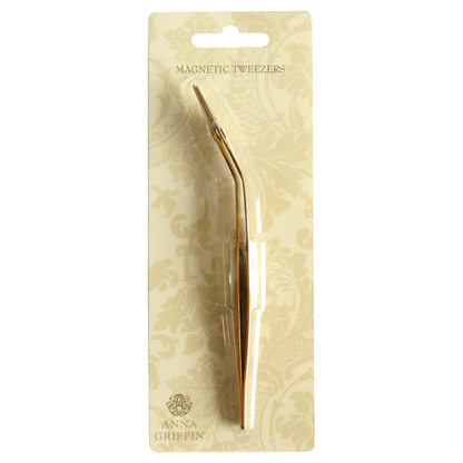 A gold plated Magnetic Tweezers in a package.