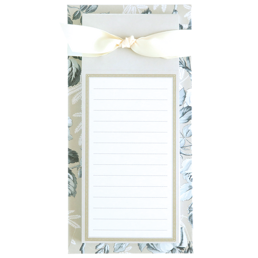 The Faded Rose List Pad is a floral-patterned notepad designed for daily tasks, with lined paper and a cream-colored bow on top.