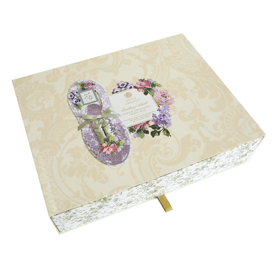 A floral-themed greeting card in the shape of Paper Sneakers on a patterned beige background with a gold ribbon, inspired by paper sneakers.