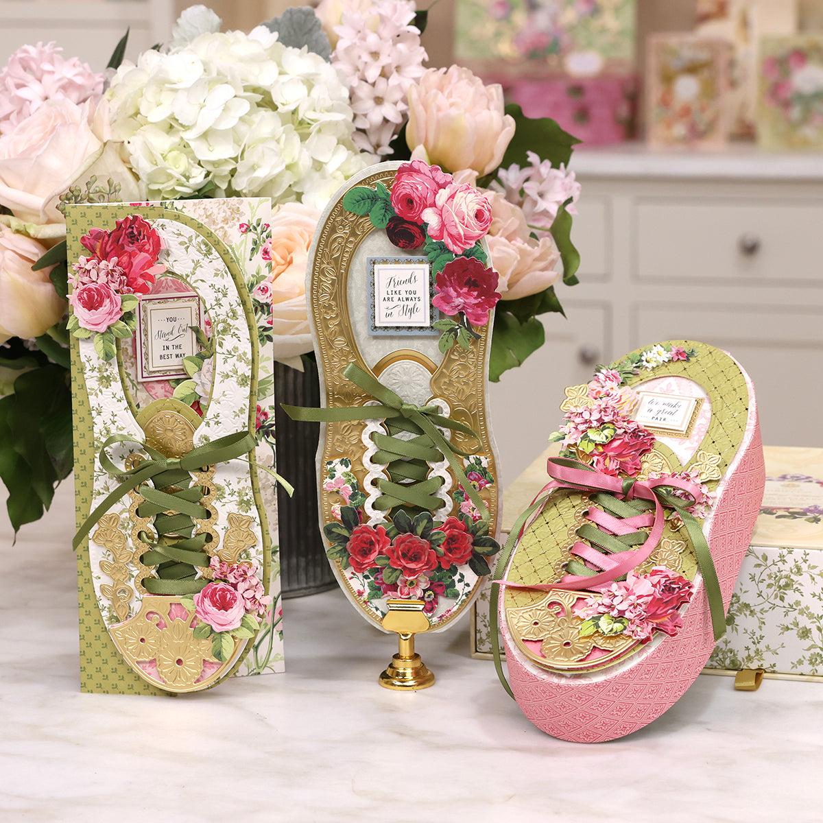 Decorative floral-themed 3D Paper Sneakers Finishing School Class cards and purse set displayed on a tabletop with a bouquet of flowers in the background.