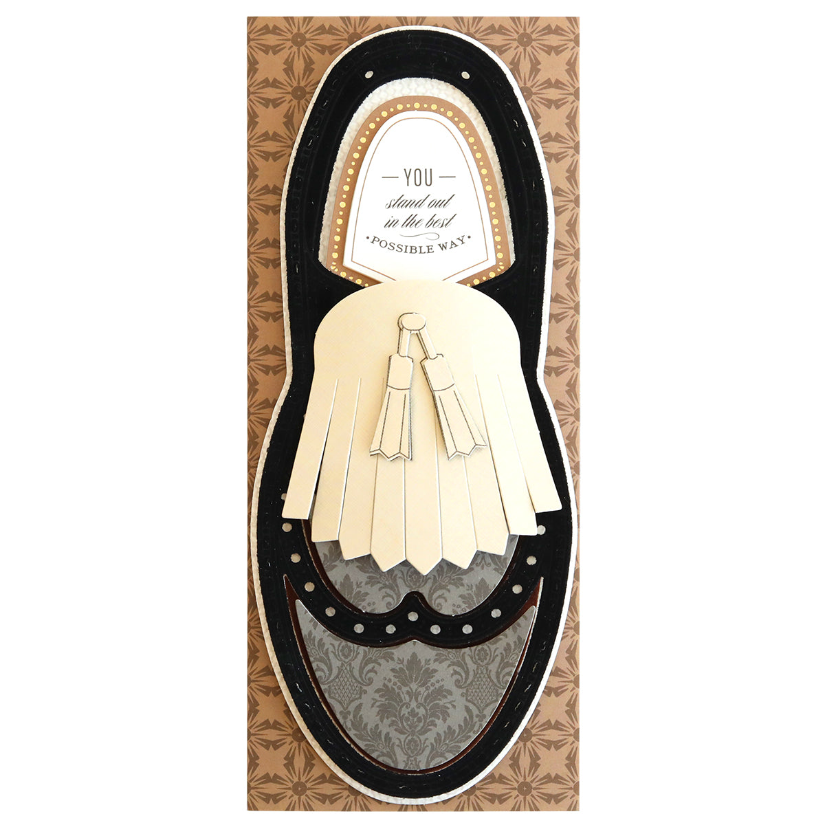 A Paper Wingtips Finishing School Craft Box shaped like a dress shoe with a tassel, containing the text "You stand out in the best possible way!" on a patterned background, perfect for adding to your craft box.