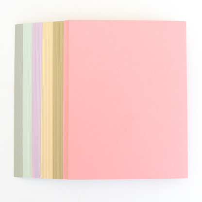 Six Perfect Palette Flocked and Printed Cardstock folders stacked together in pastel shades, with the top one pink and edges of green, lavender, yellow, and beige visible—perfect for cardmaking.