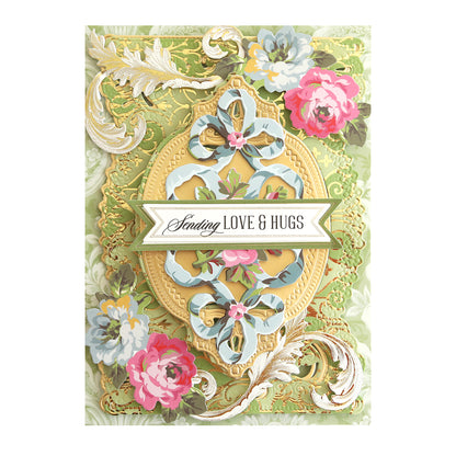 A decorative card with floral patterns, gold craft embellishments, and the text "Sending LOVE & HUGS" in the center. Perfect for adding to your collection of Phoebe Papers and Embellishments.