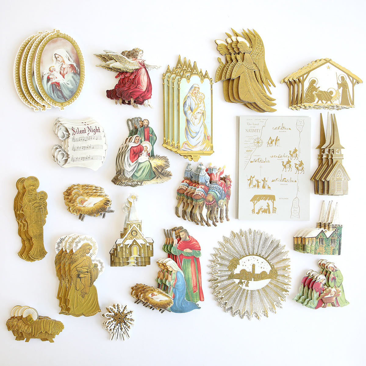 A collection of vintage Christmas and nativity-themed cutout decorations laid out on a white background, including images of angels, shepherds, the holy family, and church buildings—perfect for embellishing your Christmas cards or adding to a Reason for the Season Embellishments storage folio.