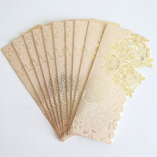 A set of ten Pink Gold Diecut Rose Pocket wedding invitations with intricate floral patterns, fanned out on a white background.