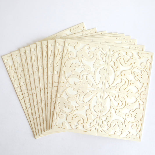A stack of Ivory Lace Diecut Gatefold invitations (10 pack) featuring an intricate, symmetrical floral pattern on a cream-colored background.