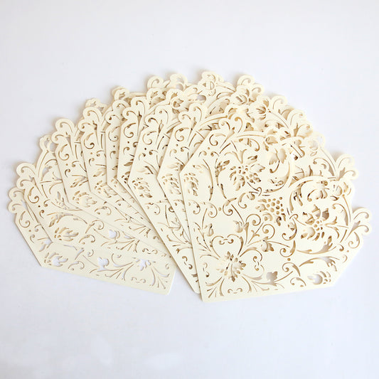 The Ivory Diecut Heart Sleeve 10 pack features intricately laser-cut, cream-colored paper sleeves with floral patterns—ideal for creating elegant wedding invitations.