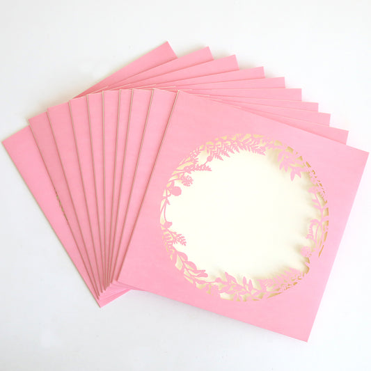A 10-pack of Pink Lasercut Circle Sleeves, each featuring a central floral circular design, is displayed fanned out on a white background.
