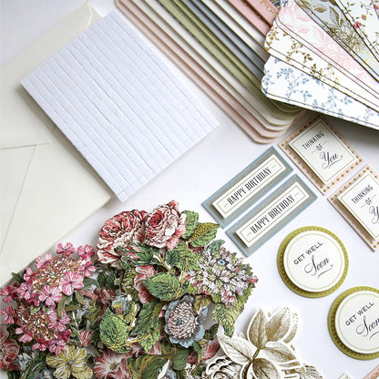 An assortment of Simply Wildflower Meadow Card Making Kit and decorative floral stickers with 3D embellishments spread out on a table.