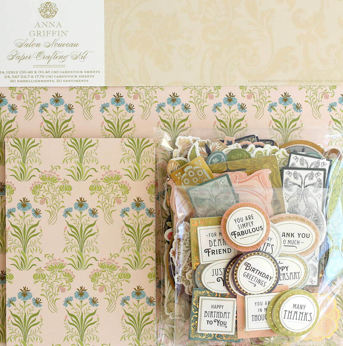 The Salon Nouveau Papercrafting Kit includes double-sided cardstock, 3D embellishment stickers, patterned paper, and sentiment tags, all in a clear package.