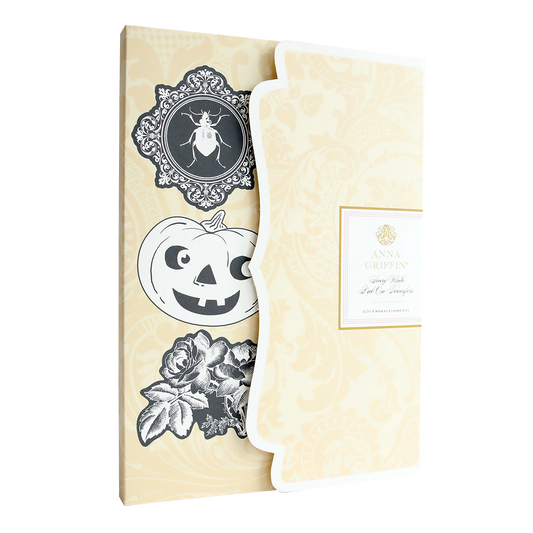 A beige Anna Griffin paper pack featuring the "Scary White Rub On Transfers" with various black and white Halloween-themed cutouts, including a pumpkin, a beetle, and a rose—perfect for creating handmade cards.