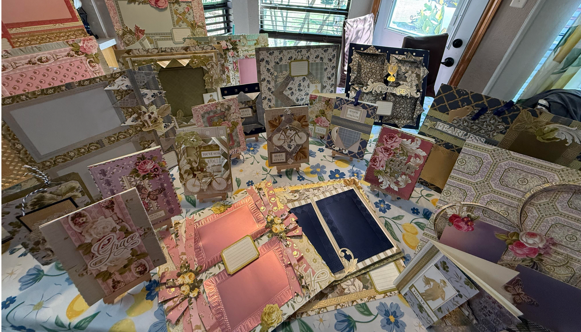 Rows of handmade floral greeting cards with ornate details and blank labels line a table, inspiring the creative community at Anna Griffin | Create Fall 2026 craft classes.