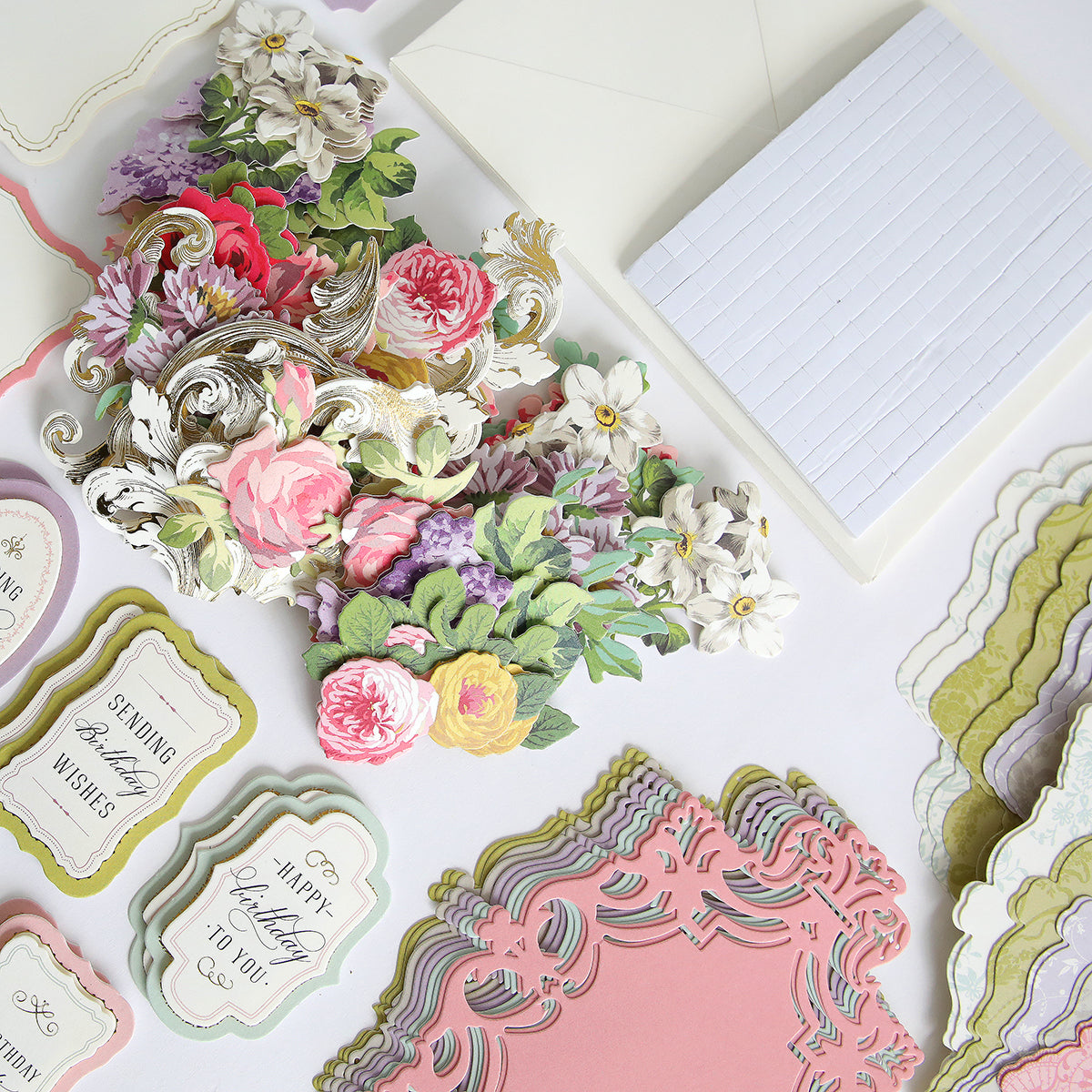 A colorful assortment of the Simply Birthday Easel Card Making Kit and papers are meticulously arranged on a table, showcasing the artistry and creativity of cardmaking. From elegant birthday easel card kits to other delightful designs, this