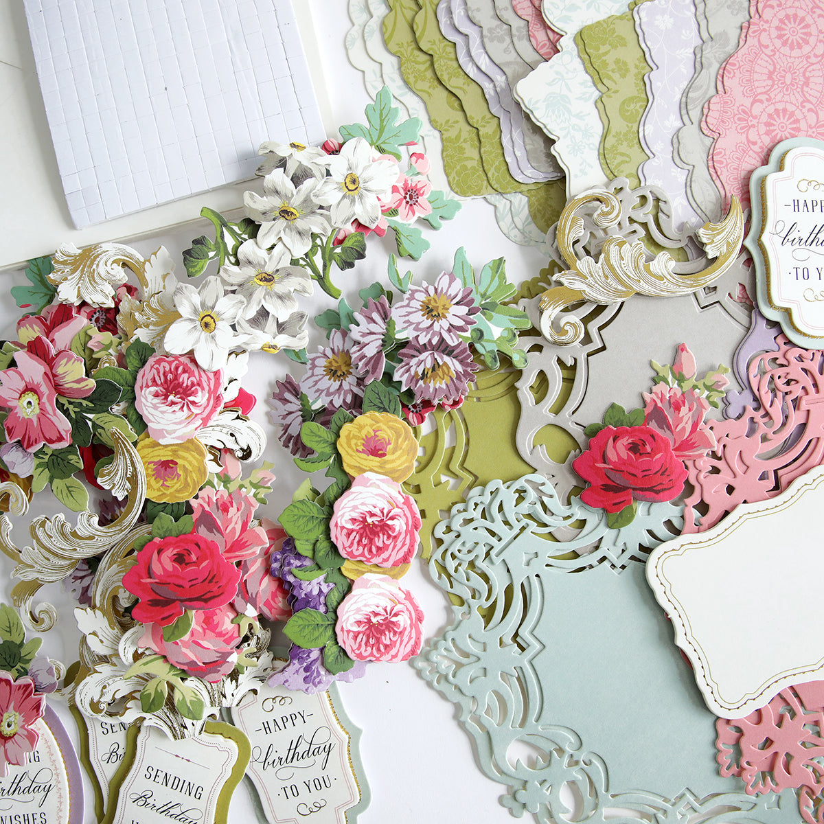 A collection of handcrafted paper cut outs and flowers on a table, showcasing a stunning Simply Birthday Easel Card Making Kit perfect for cardmaking enthusiasts wanting to create unique and beautiful handmade cards.