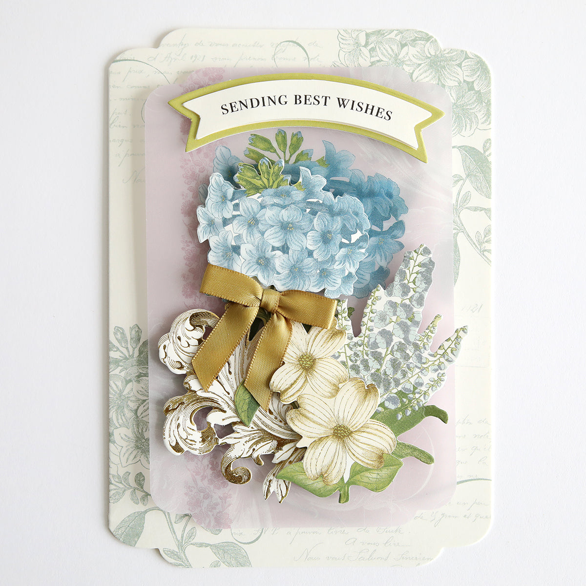 Simply Perfect Patterns Card Making Kit featuring a floral arrangement with blue and white flowers, adorned with a golden ribbon and 3D embellishments, on a vintage background with text "sending best wishes.