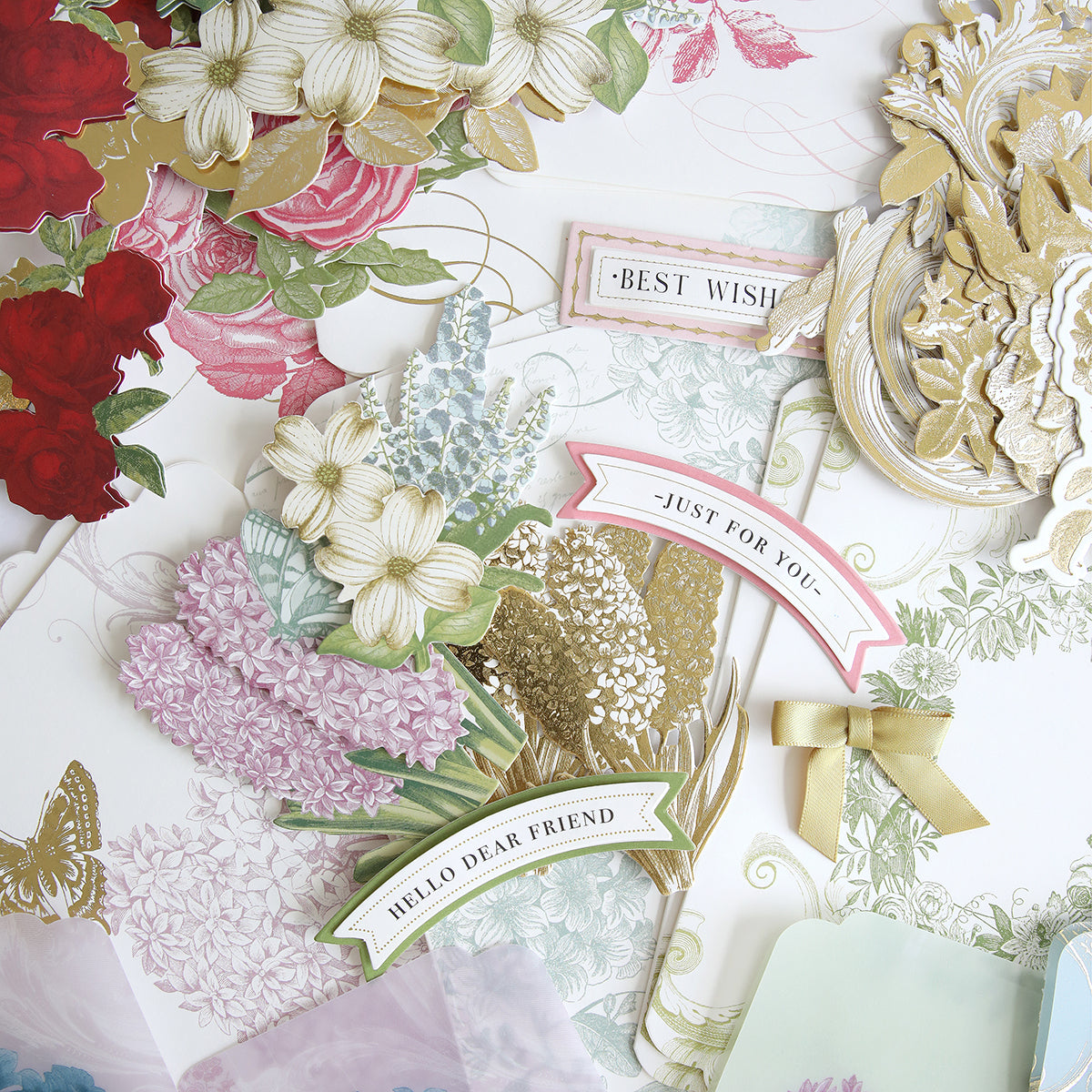 A collection of various floral and butterfly-themed paper crafts, including handmade cards with phrases like "best wishes" and "just for you," from the Simply Perfect Patterns Card Making Kit.
