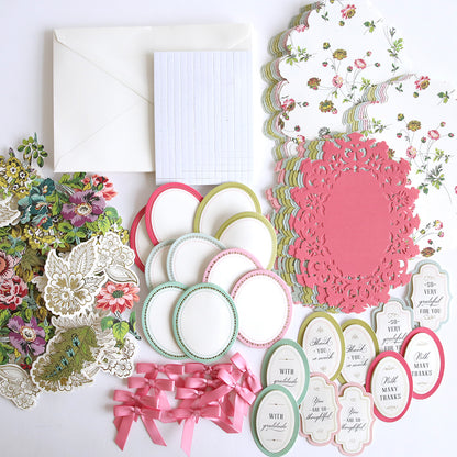 An assortment of 2024 Simply Easel Card Making Kit Autoship materials for the experienced crafter including patterned paper cutouts, floral stickers, decorative labels, ribbons, and envelopes on a white background.