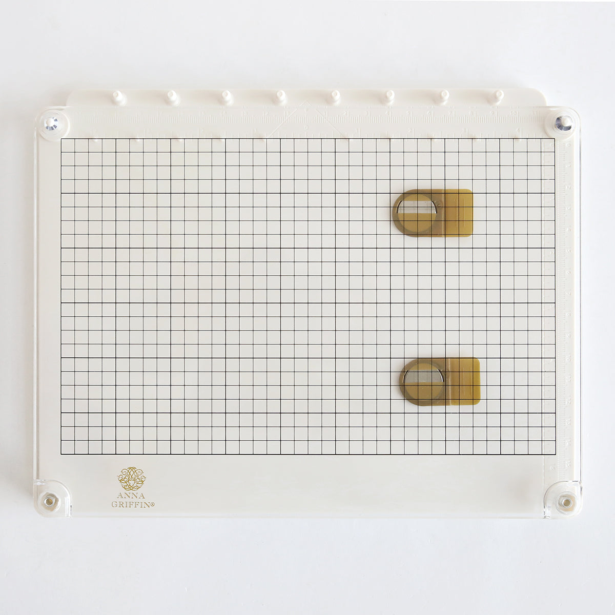 A white cutting board with a grid and Stamp Platform and Alignment Tool on it.