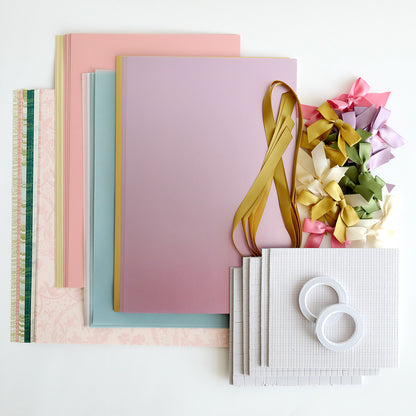 Crop at Home 5 Swag Materials, including premium pastel papers, ribbons, bows, two tape rolls, and textured sheets, are arranged on a white surface.