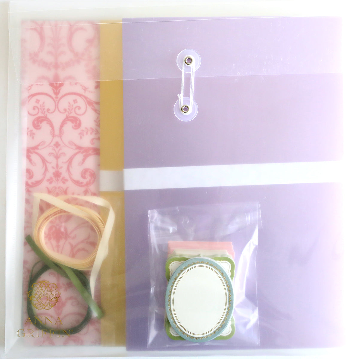 Introducing the Crop at Home 4 Scrapbook Collection: a stationery set that includes pastel-colored folders, ribbons, a patterned sheet, and a small packet of labels—ideal for enhancing your Crop at Home sessions.