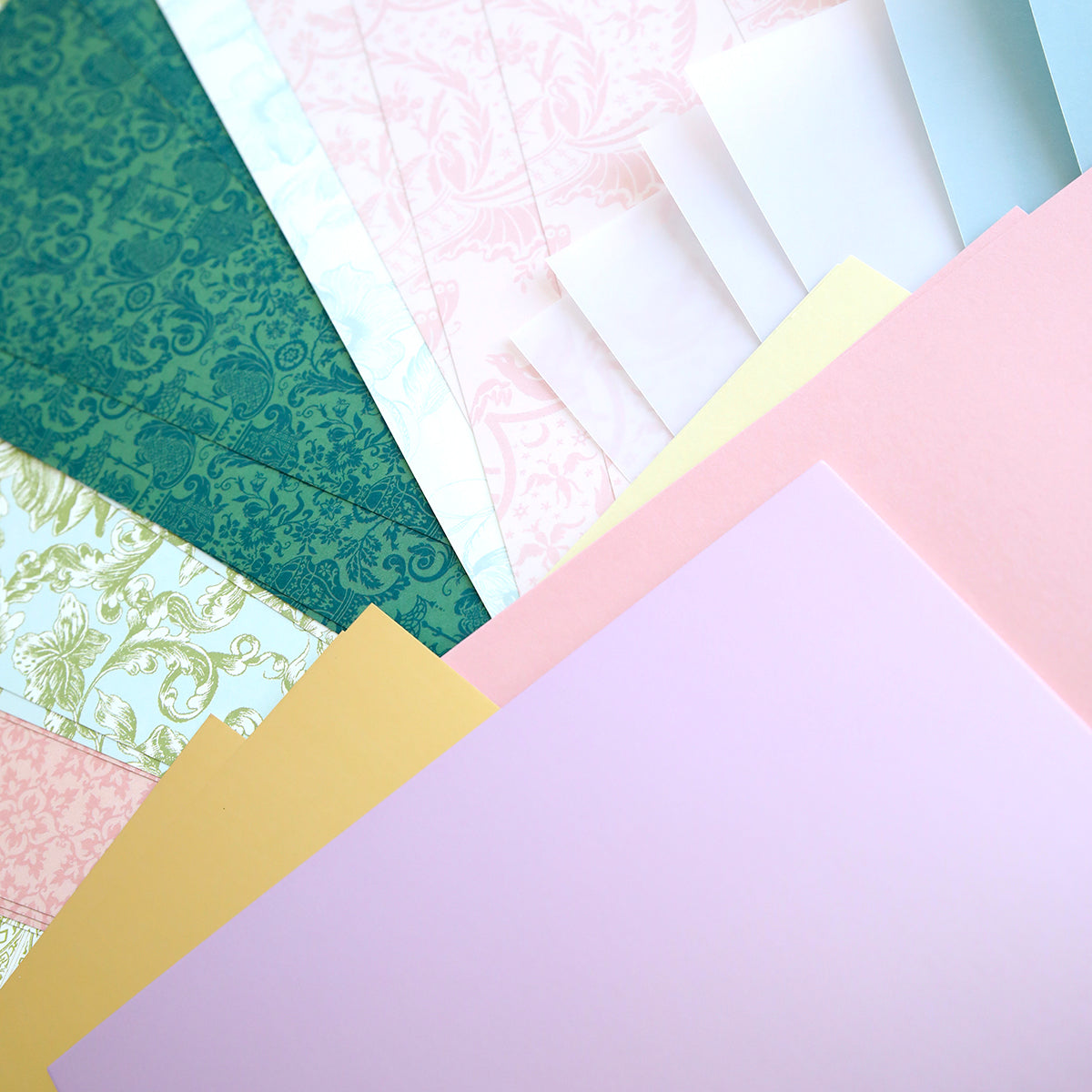 Crop at Home 5 Swag Materials: a selection of premium patterned and solid papers fanned out—ideal crafting supplies for your next Crop at Home 5 project.