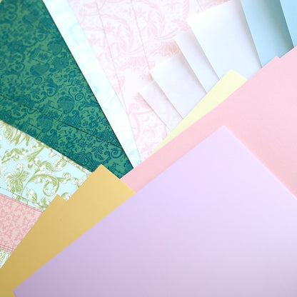 Crop at Home 5 Swag Materials: a selection of premium patterned and solid papers fanned out—ideal crafting supplies for your next Crop at Home 5 project.
