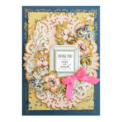Handmade greeting card featuring a Thankful Sentiments and Floral Stickers rub-on tag decorated with die-cut flowers, lacy borders, and a pink ribbon.