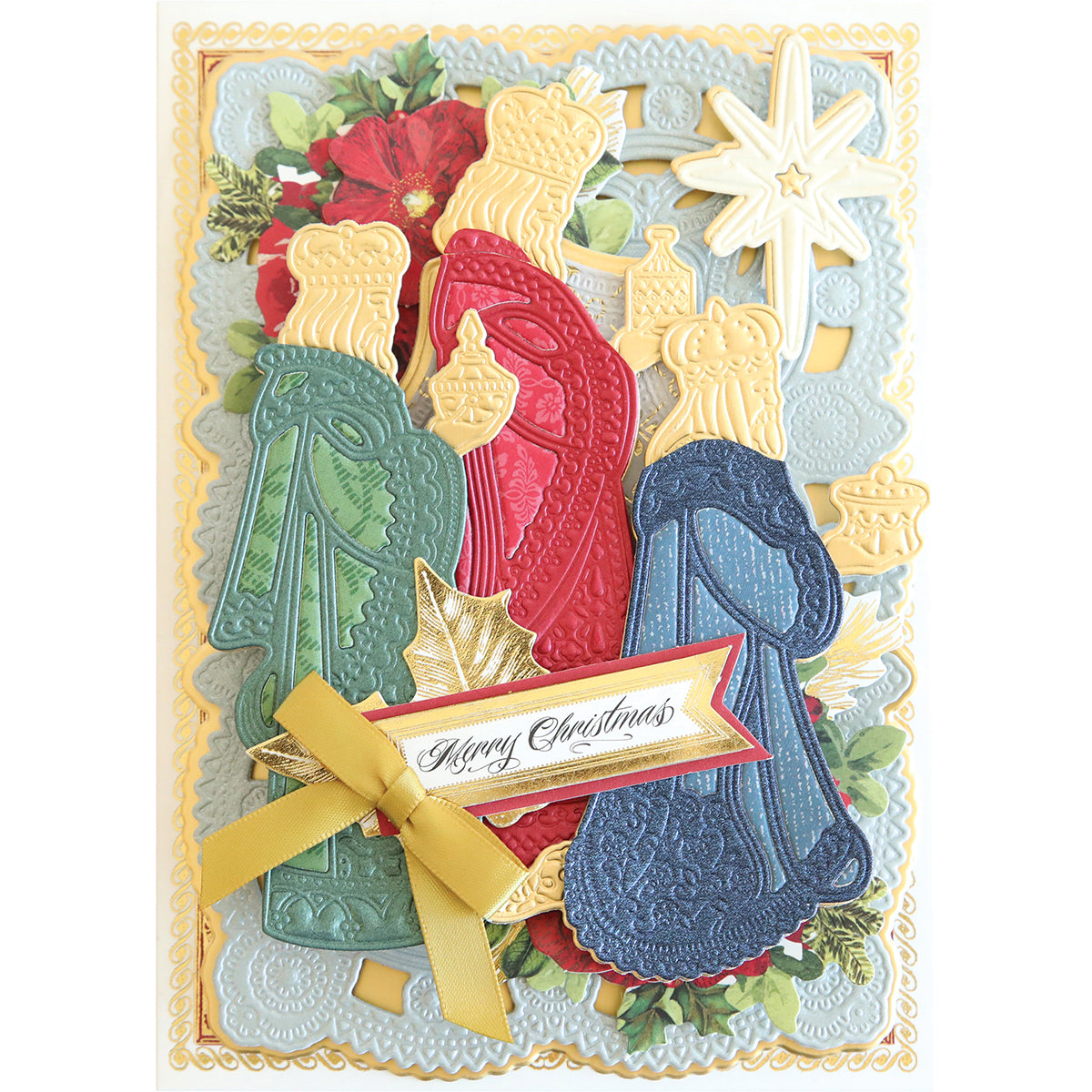 A Christmas card with intricate lace-like patterns, featuring the Three Wise Men 3D Dies in a layered design holding gifts, a gold Star of Wonder in the top right, and a gold ribbon with "Merry Christmas" text.