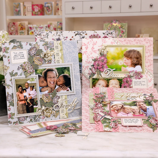 A variety of scrapbooking pages and materials from the Wildflower Meadow Finishing School Class displayed on a table, featuring decorative patterns and family photos.