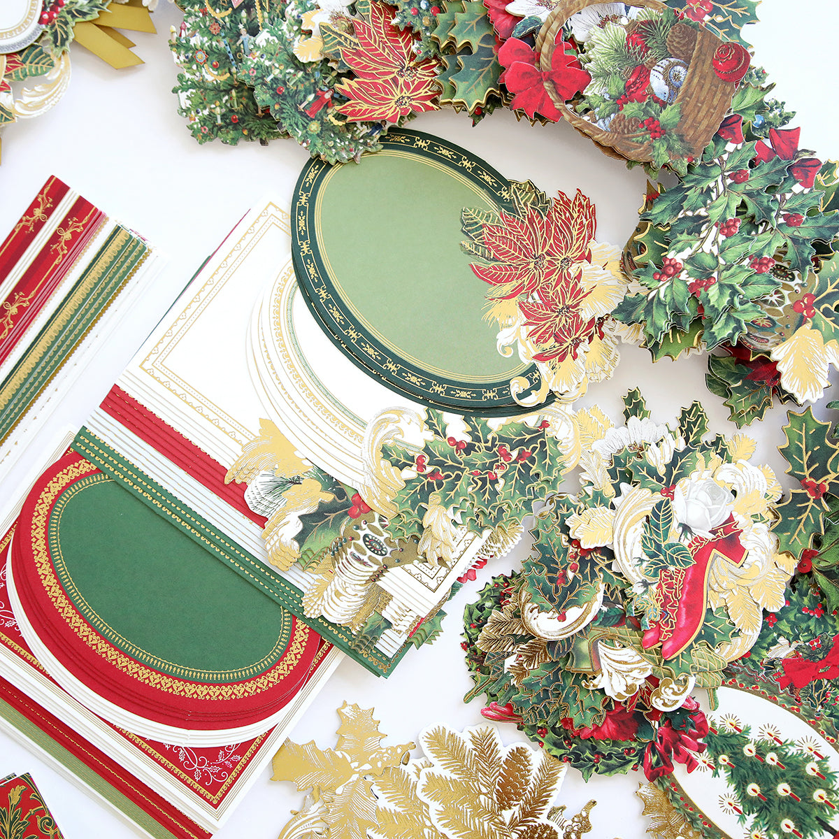 Assorted holiday-themed paper crafts and decorations, featuring red, green, and gold colors along with floral and leaf motifs. Perfect for a Christmas Greetings Card Making Kit to create festive greeting cards that spread holiday cheer.