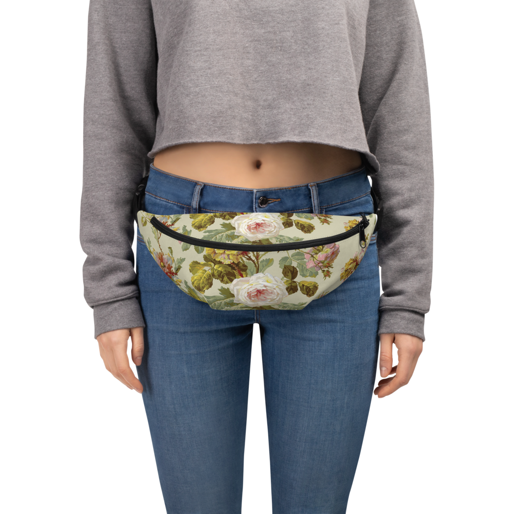 A person sports a gray cropped sweatshirt and blue jeans, effortlessly accessorized with a large floral Fanny Pack featuring adjustable straps.