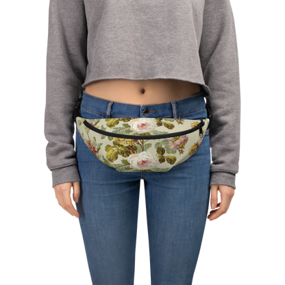 A person sports a gray cropped sweatshirt and blue jeans, effortlessly accessorized with a large floral Fanny Pack featuring adjustable straps.
