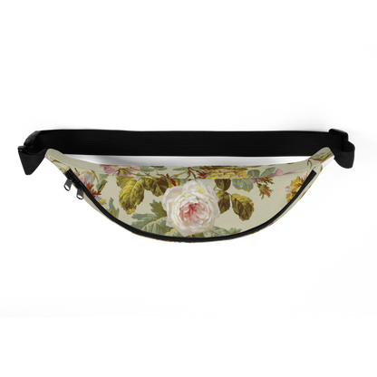 The Fanny Pack features a large white rose with lush green leaves on a beige background, complemented by adjustable black straps against a plain black backdrop.