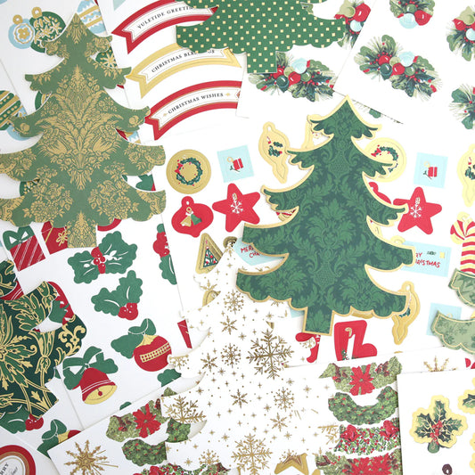Assorted Christmas-themed paper cutouts and stickers, including decorated trees, holly, stars, ornaments, and festive greetings, arranged in an overlapping display.