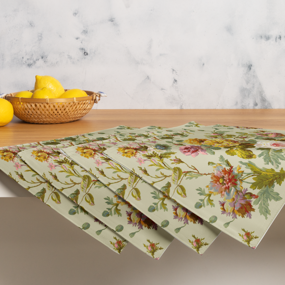 Four floral-patterned placemats from the Placemat Set of 4 are on a wooden table, with a basket of lemons nearby, showcasing customizable dining decor that adds charm to any setting.