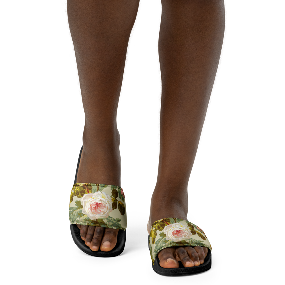 A person in Women's Slides, featuring floral-patterned faux leather and a cushioned footbed, stands on a white background.
