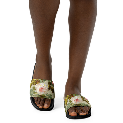 A person in Women's Slides, featuring floral-patterned faux leather and a cushioned footbed, stands on a white background.