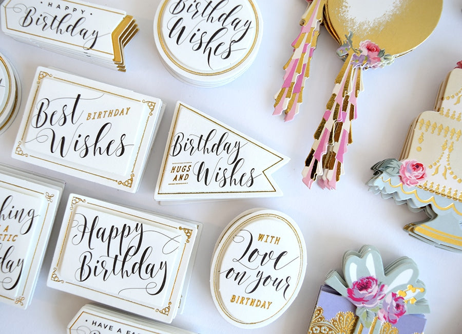 a table topped with lots of white and gold signs.