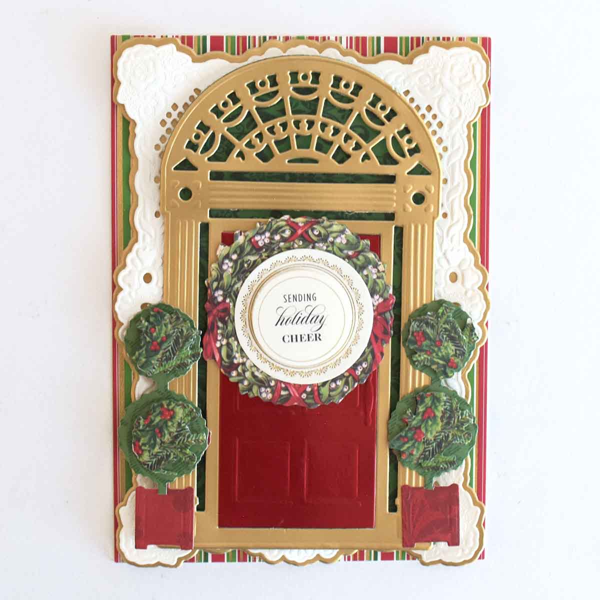 a christmas card with a red door and wreath.