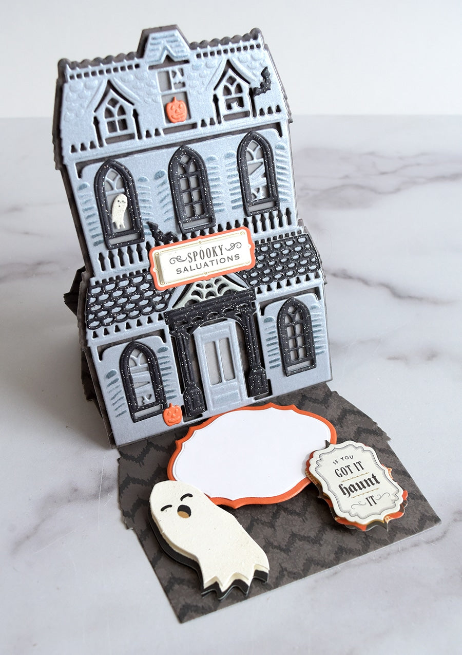 a halloween card with a ghost and a ghost house.