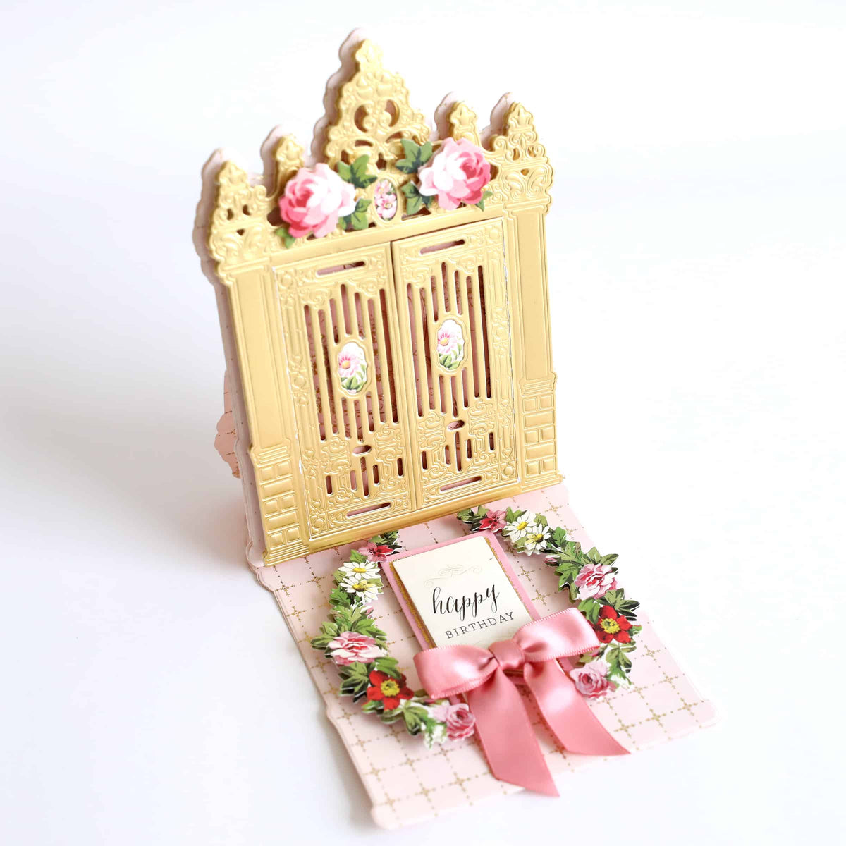 a card with a pink ribbon around it.
