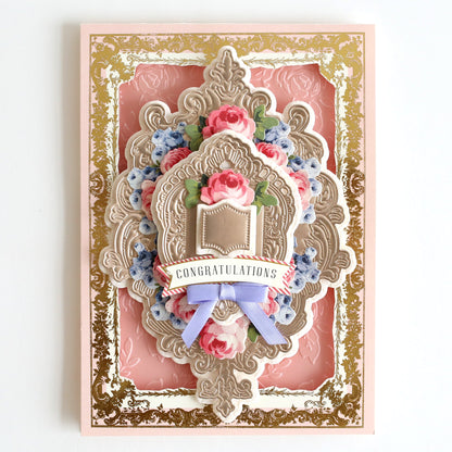 a pink and gold card with a crown on it.