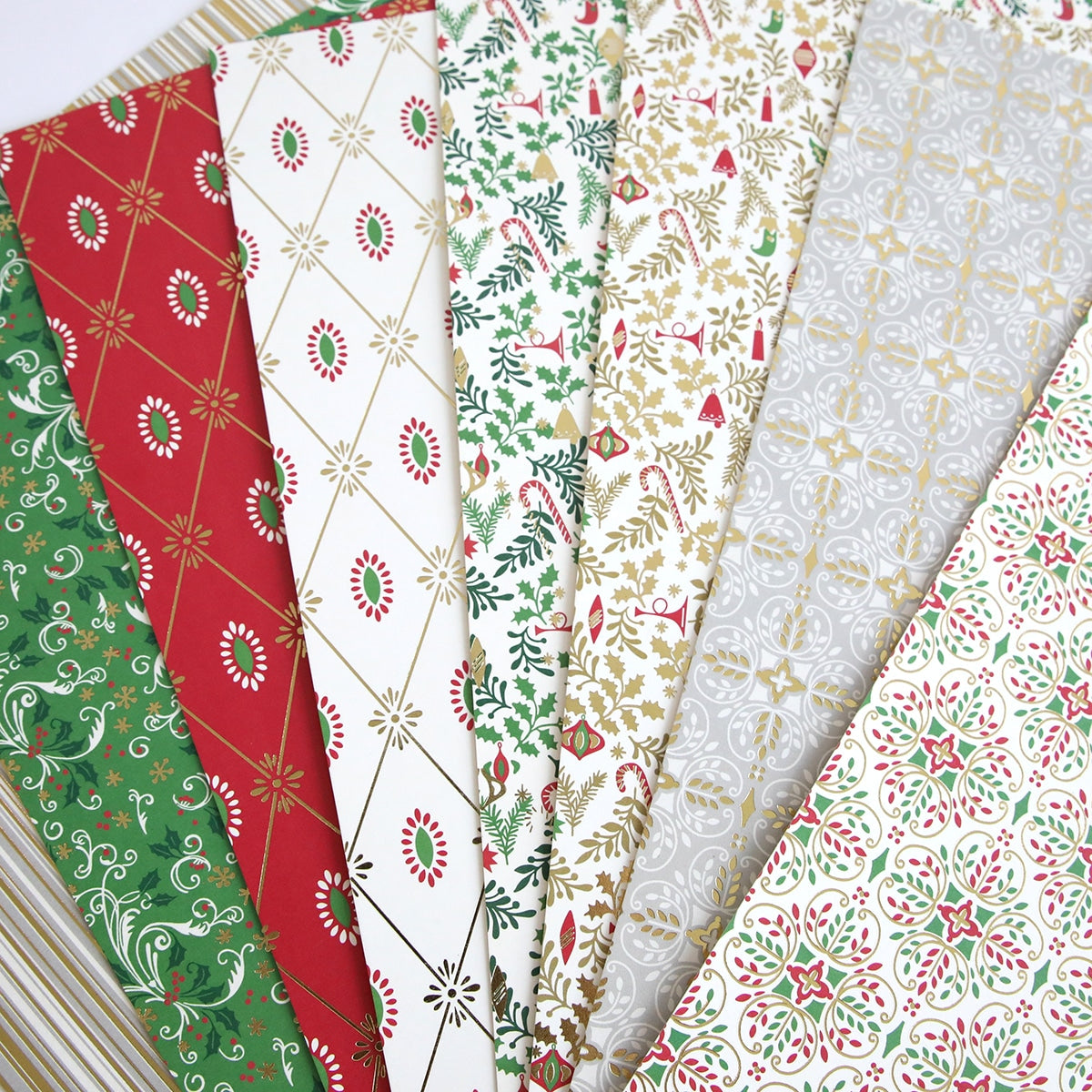 A stack of Christmas 12x12 Cardstock with red, green, and gold designs.